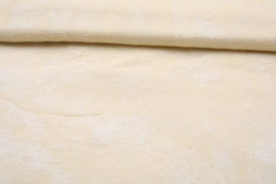 Raw puff pastry dough as background, closeup