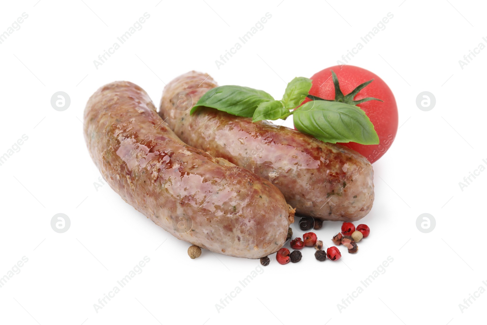 Photo of Tasty homemade sausages, peppercorns, tomato and basil leaves isolated on white