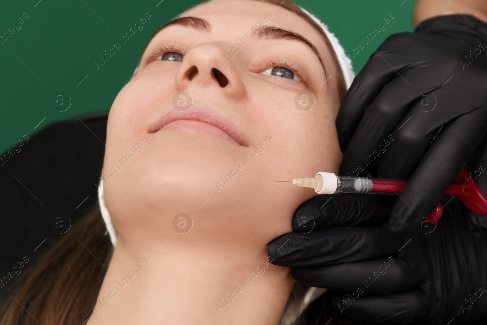 Photo of Cosmetologist giving facial injection to patient, closeup. Cosmetic surgery