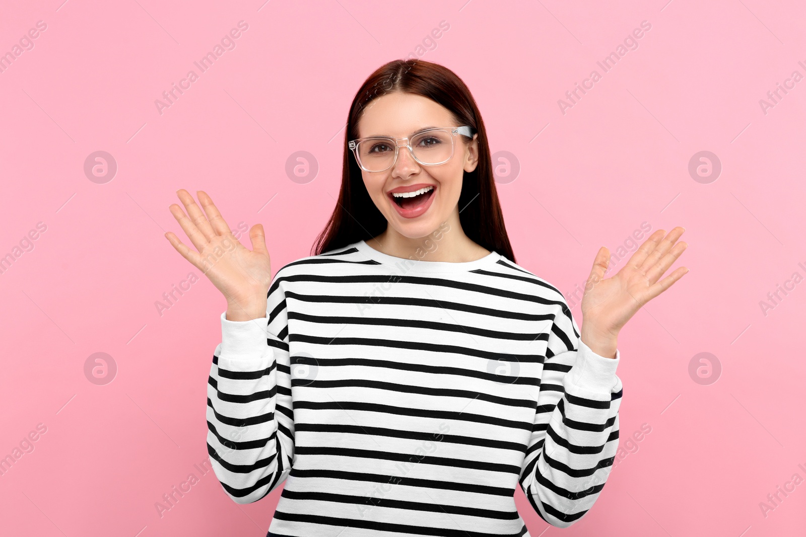 Photo of Portrait of emotional woman in stylish eyeglasses on pink background
