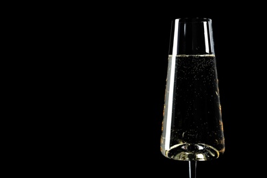 Photo of Glass of champagne on black background, space for text