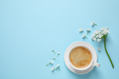 Photo of White flowers and coffee on light blue background, flat lay with space for text. Good morning