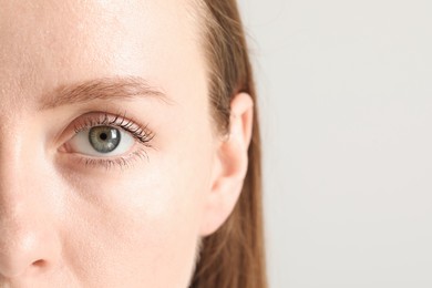 Closeup photo of woman with beautiful eyes on light background. Space for text