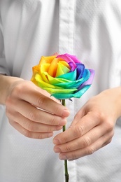 Photo of Woman holding rainbow rose flower, closeup