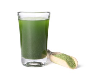 Photo of Wheat grass drink in shot glass and scoop with green powder isolated on white
