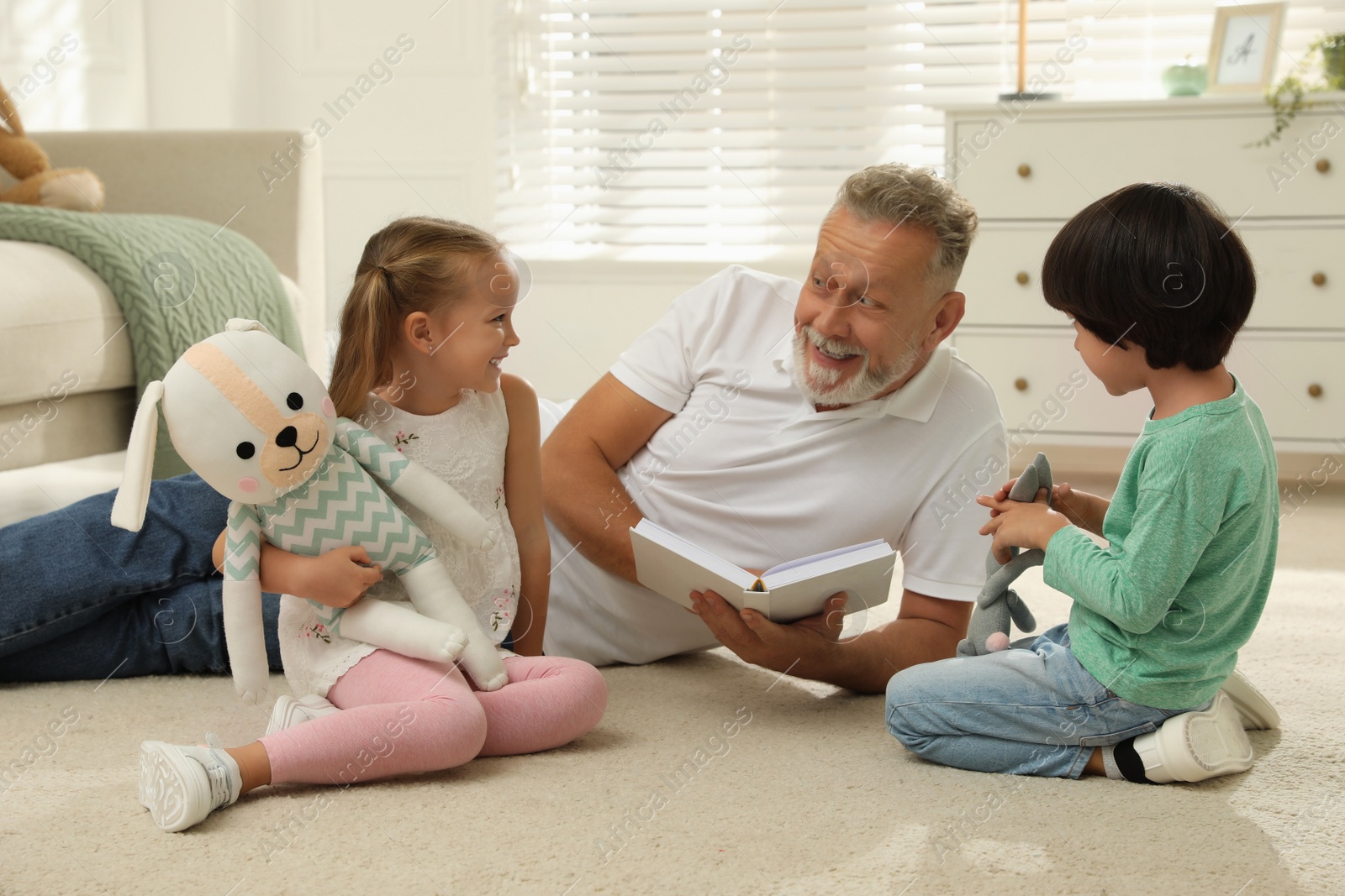 Photo of Happy grandfather and his grandchildren spending time together at home