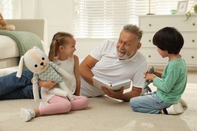 Photo of Happy grandfather and his grandchildren spending time together at home