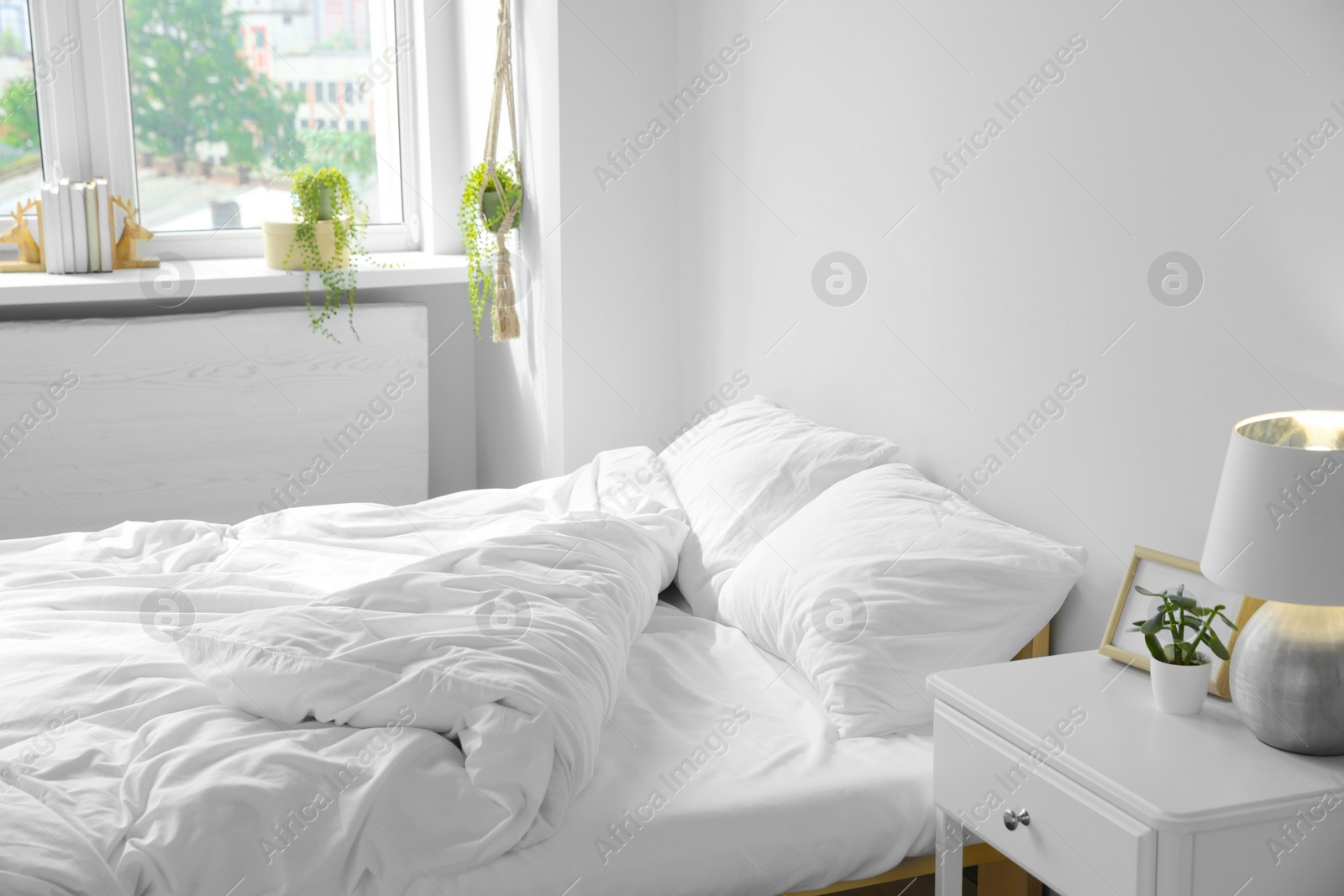 Photo of Large comfortable bed with soft pillows and blanket indoors