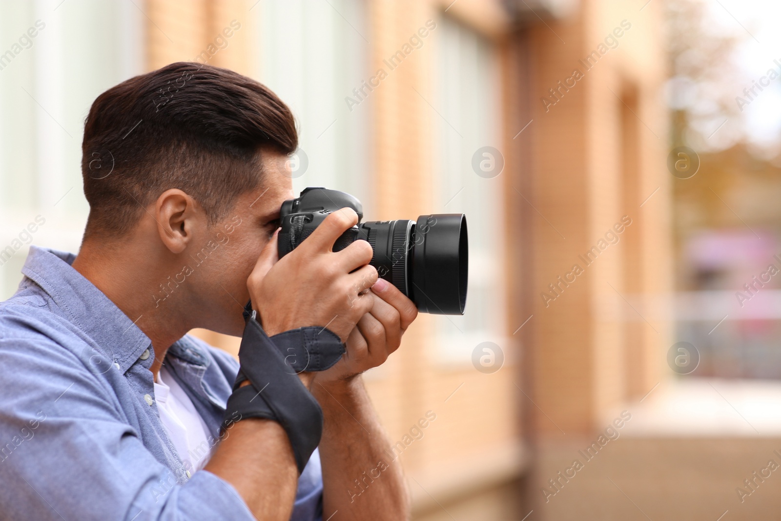 Photo of Photographer taking picture with professional camera outdoors