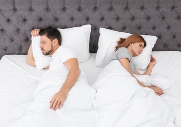 Couple with relationship problems in bed at home