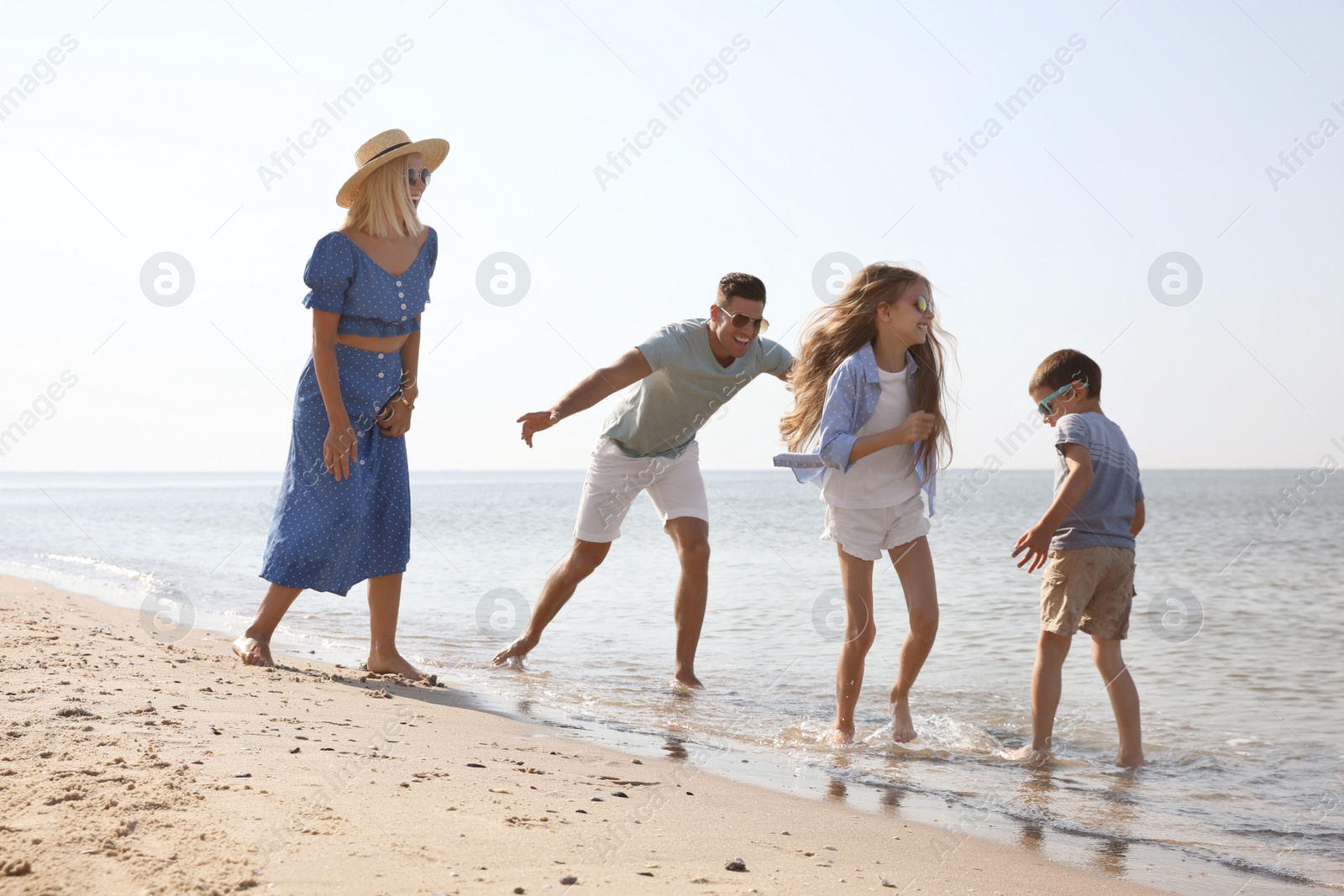 Photo of Happy family at beach on sunny summer day