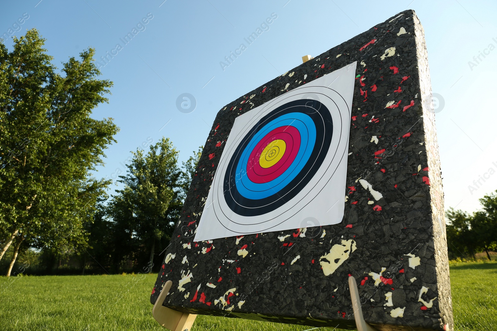 Photo of Tripod with archery target on green grass in park