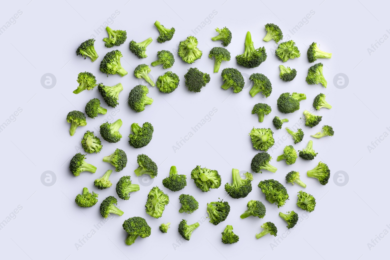 Photo of Frame made of many fresh green broccoli pieces on white background, flat lay. Space for text