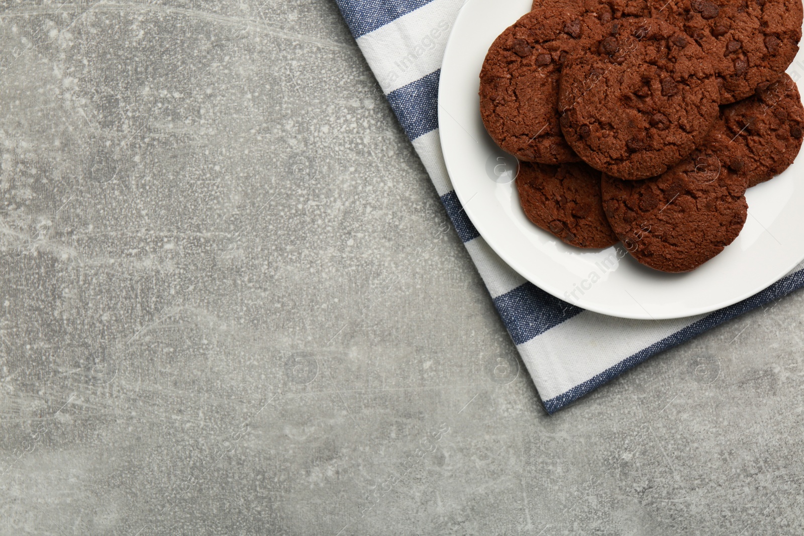 Photo of Delicious chocolate chip cookies on light grey table, top view. Space for text