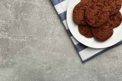 Photo of Delicious chocolate chip cookies on light grey table, top view. Space for text