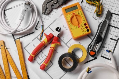 Photo of Different wires and tools on electrical schemes, top view