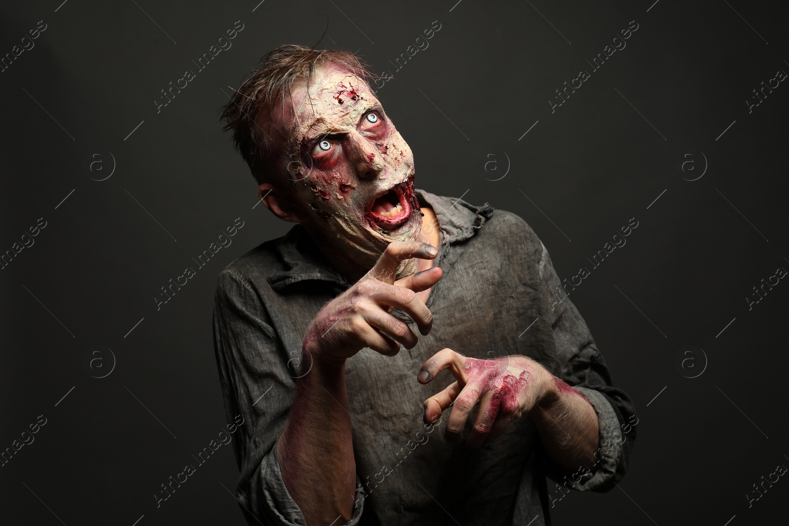 Photo of Scary zombie on dark background. Halloween monster