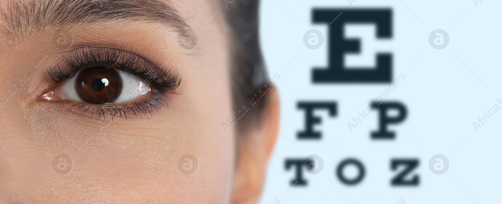 Image of Closeup view of woman and blurred eye chart on background, banner design. Visiting ophthalmologist 