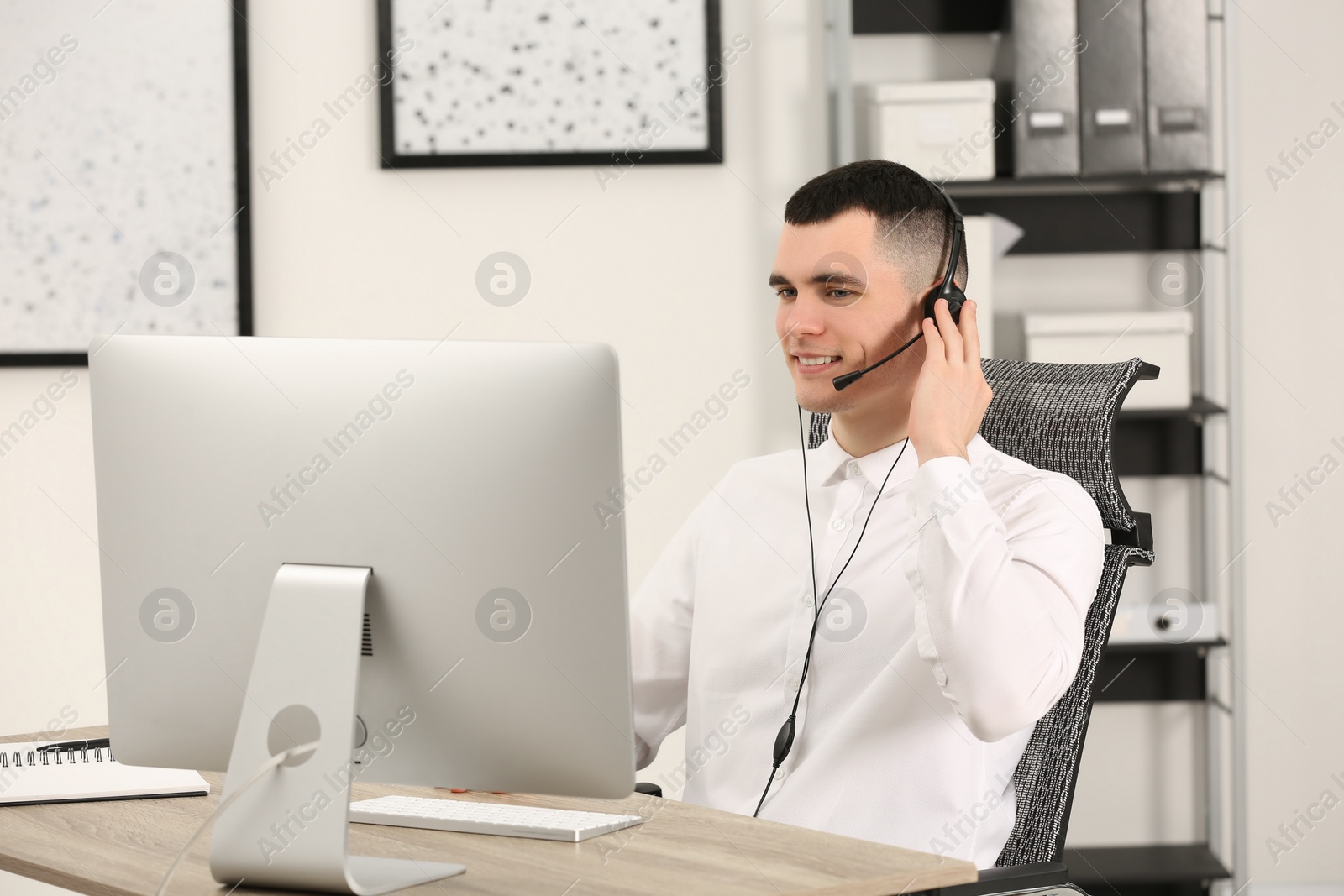 Photo of Hotline operator with headset working in office