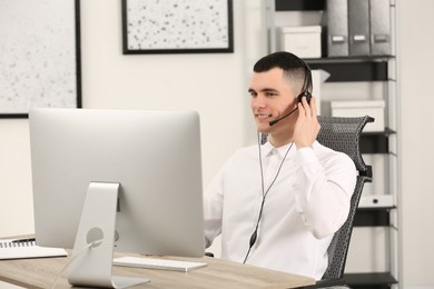 Hotline operator with headset working in office