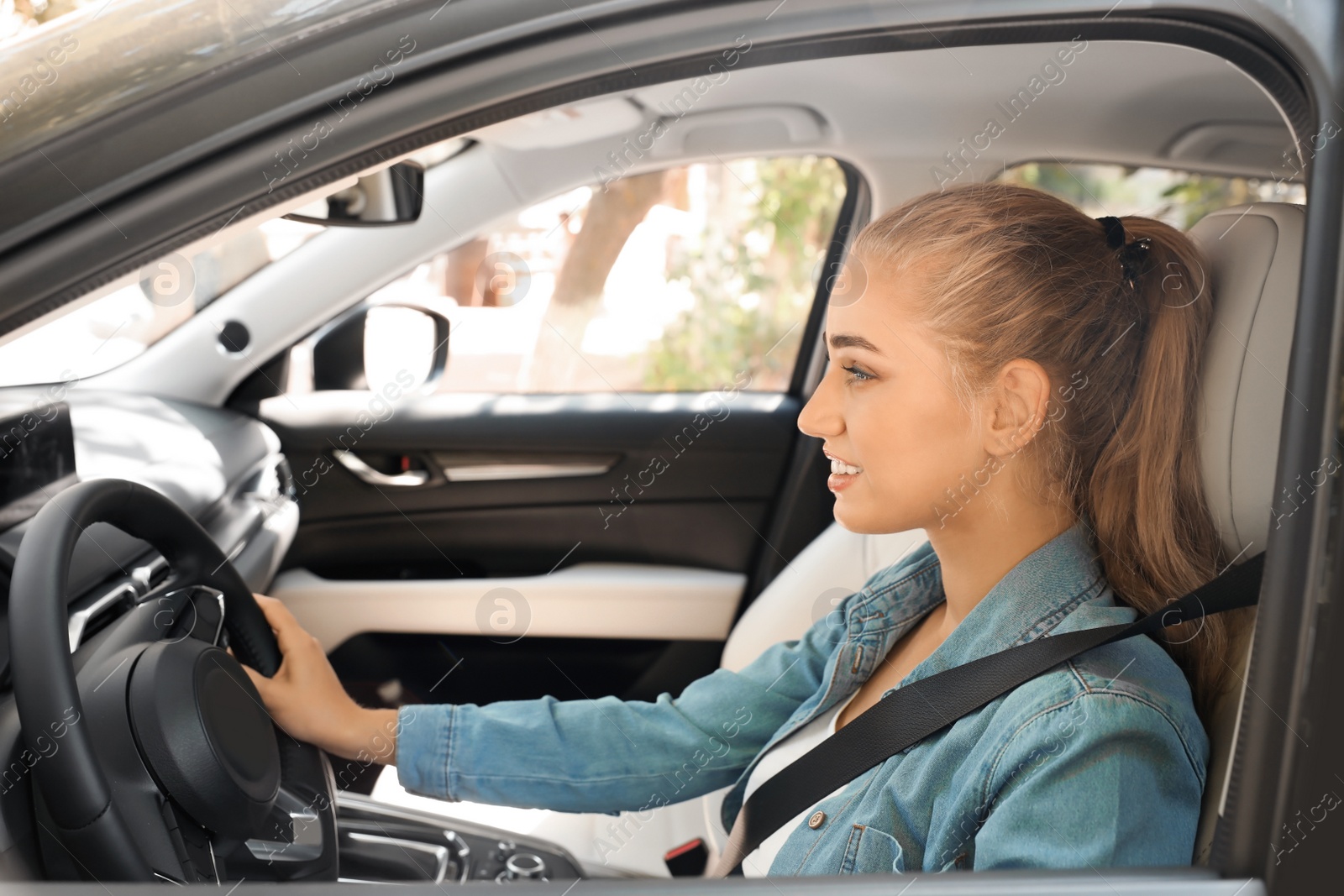 Photo of Female driver with fastened safety belt in car