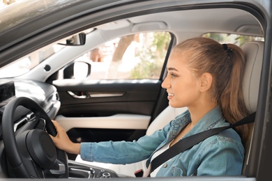 Female driver with fastened safety belt in car