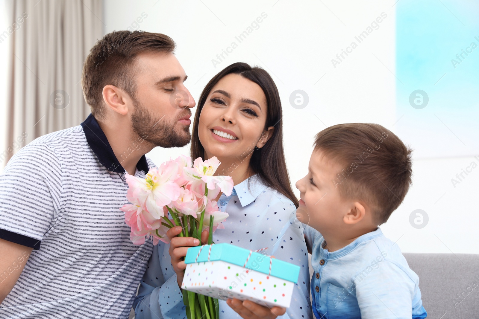 Photo of Father and son congratulating mom at home. Happy Mother's Day