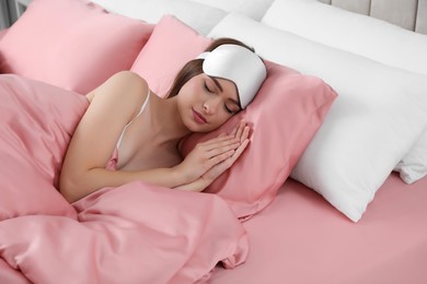 Photo of Young woman sleeping in comfortable bed with silky linens
