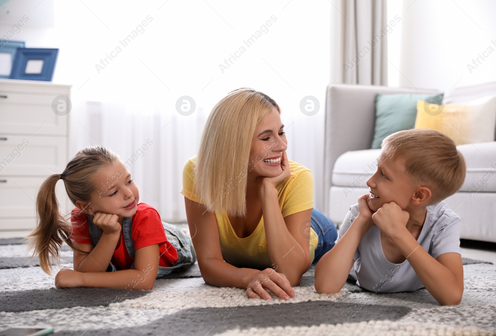Photo of Happy mother with her children on floor at home