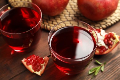 Photo of Pomegranate juice and fresh fruits on wooden table