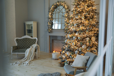 Photo of Festive room interior with stylish furniture and beautiful Christmas tree, view through window