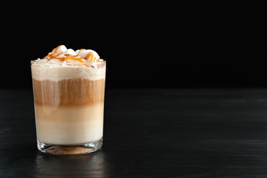 Photo of Glass with delicious caramel frappe on table