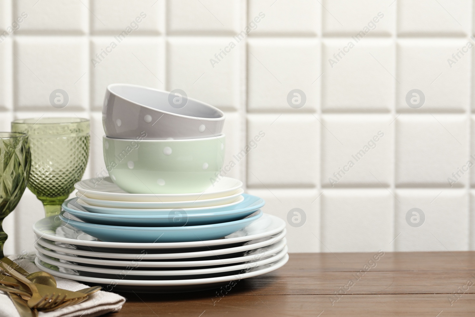 Photo of Beautiful ceramic dishware, glasses and cutlery on wooden table, space for text