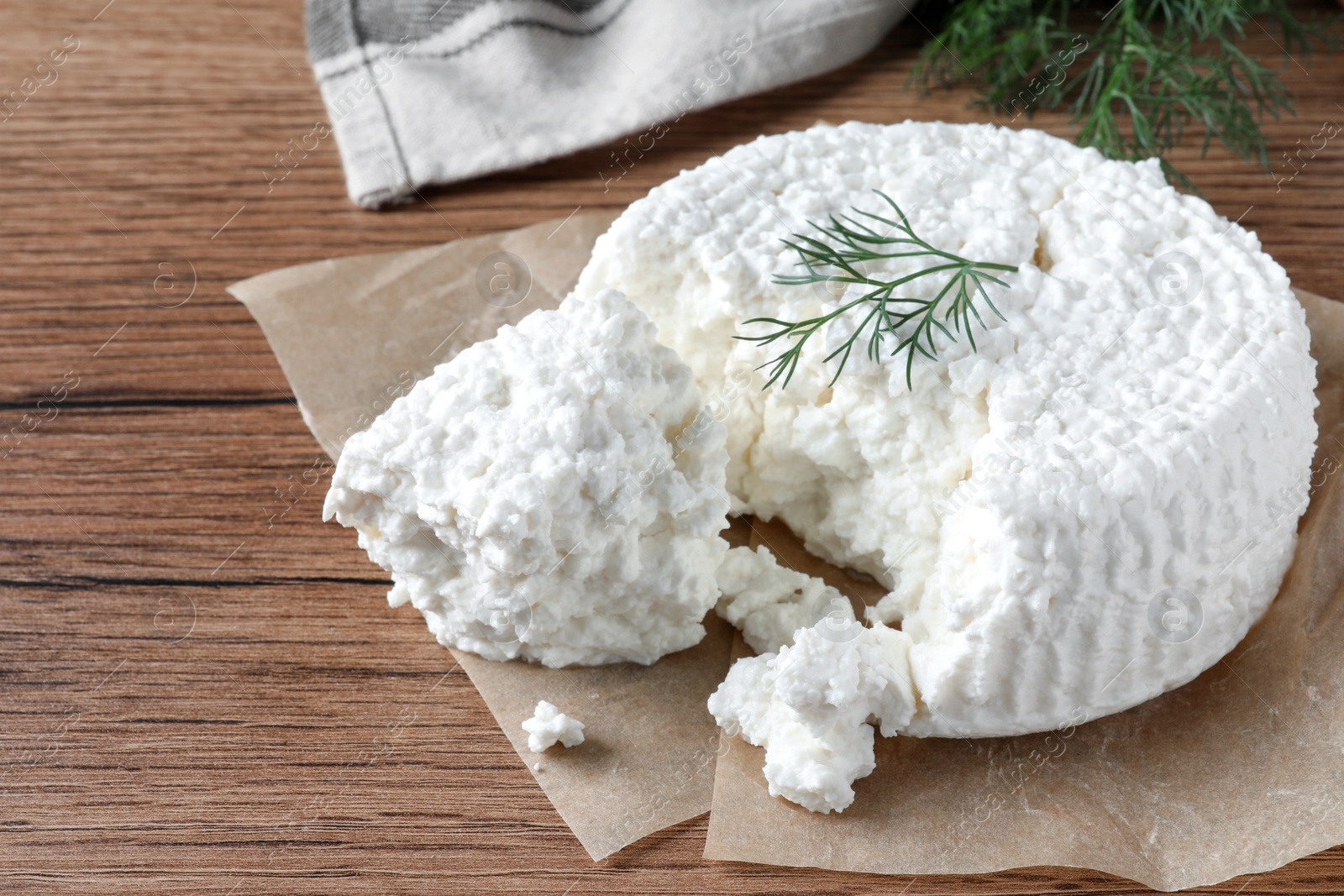 Photo of Delicious cottage cheese with dill on wooden table