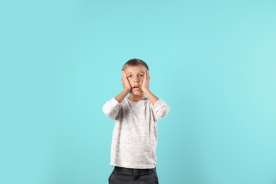 Adorable little boy in casual clothes on color background