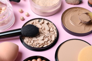 Photo of Composition with skin foundation, powder and beauty accessories on color background