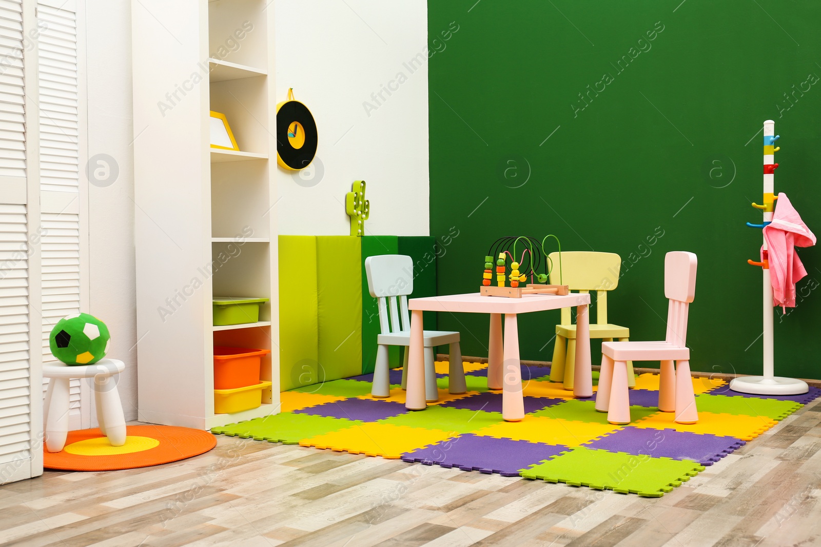 Photo of Stylish playroom interior with table and chairs