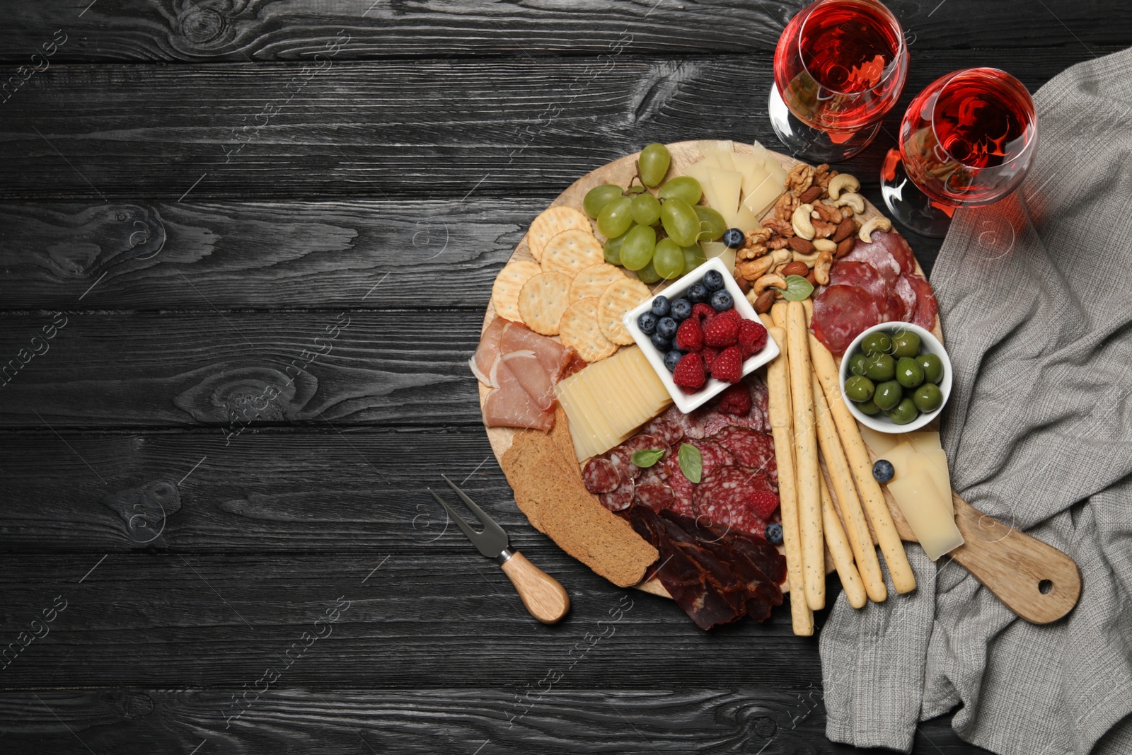 Photo of Wine and snack set with delicious Parmesan cheese on black wooden table, flat lay. Space for text