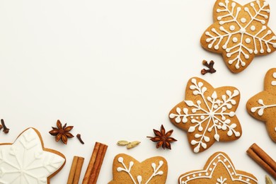 Tasty Christmas cookies with icing and spices on white background, flat lay. Space for text