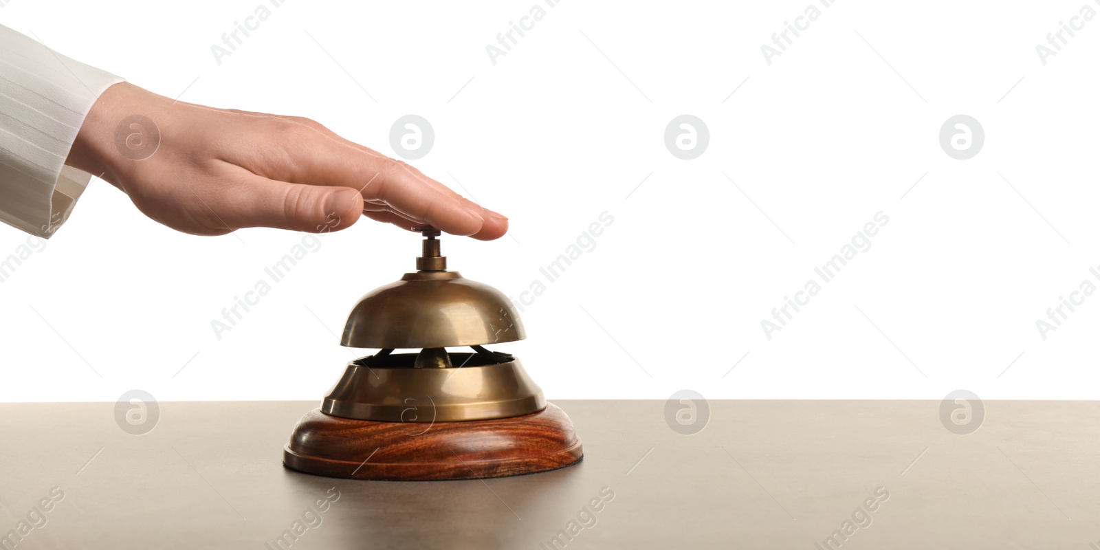 Photo of Woman ringing hotel service bell at grey stone table