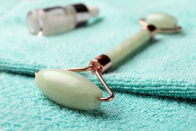 Photo of Natural jade face roller on towel, closeup view