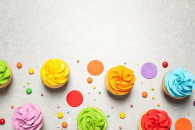 Photo of Colorful birthday cupcakes on light grey table, flat lay. Space for text