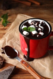 Photo of Mug of delicious hot chocolate with marshmallows and fresh mint served on wooden table
