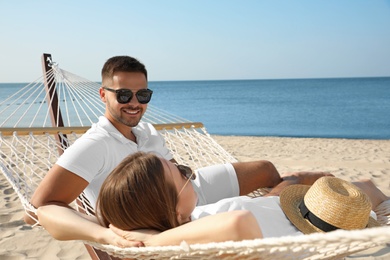 Photo of Young lovely relaxing in hammock on beach