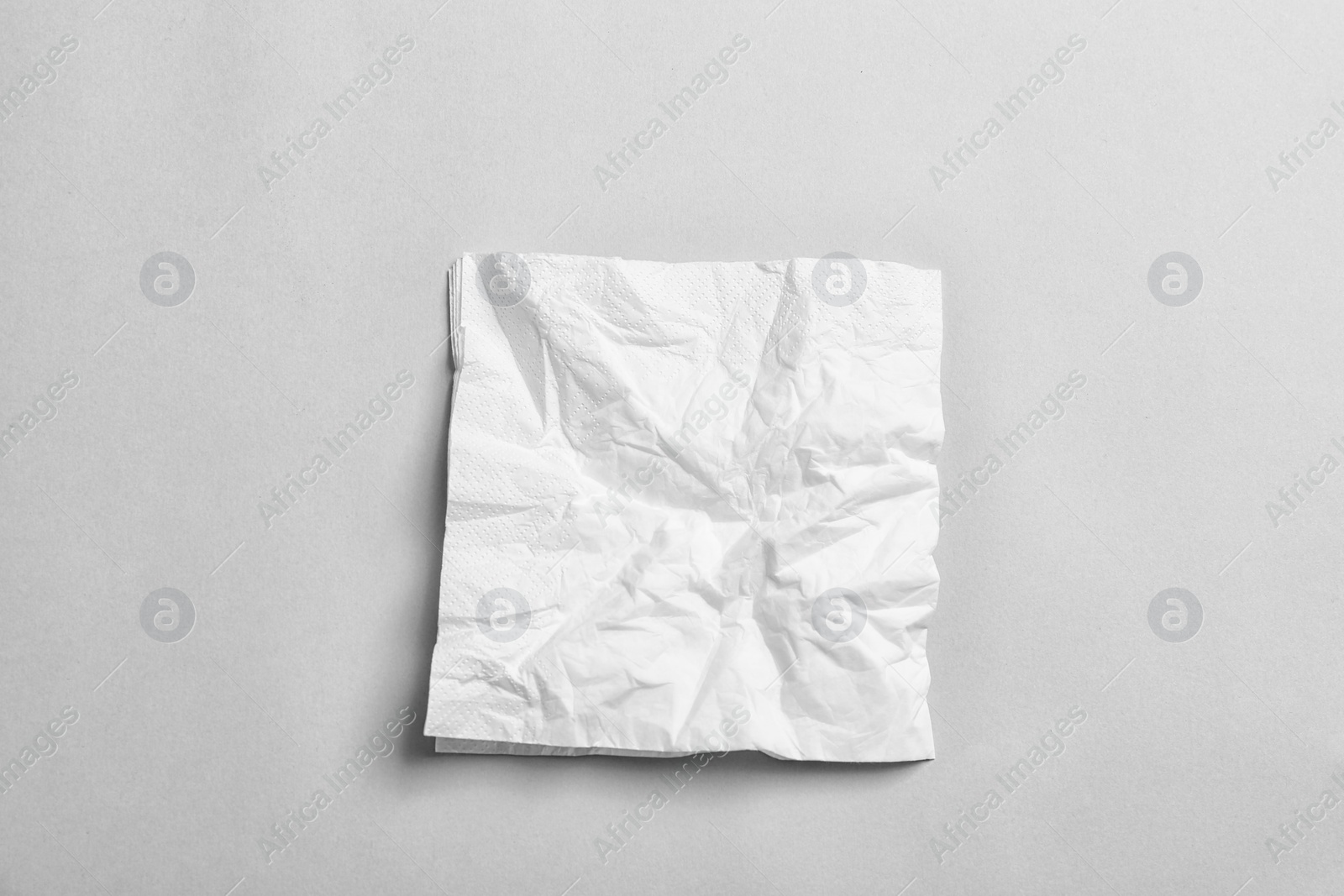 Photo of Crumpled napkin on grey background, top view. Personal hygiene