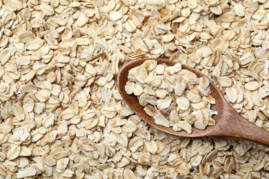 Photo of Closeup of wooden spoon on oatmeal, top view