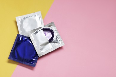 Photo of Packaged condoms on color background, flat lay with space for text. Safe sex