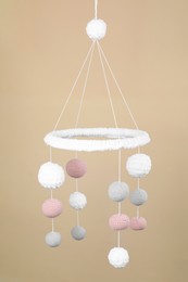 Photo of Cute baby crib mobile on beige background