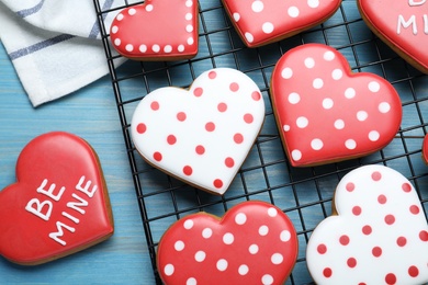 Decorated heart shaped cookies on blue wooden table, flat lay. Valentine's day treat
