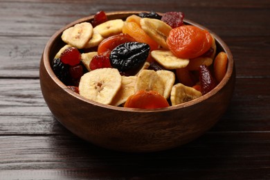 Photo of Mix of delicious dried fruits on wooden table, closeup